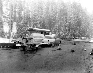 Crater Lake National Park Entrance, historic photograph Black and white print, 1960 Photographer: Jack E. Boucher Image source: NPS Historic Photograph Collection (online) at Harper's Ferry web site. Description: A heavy summer snowstorm has a boat and trailer combination pausing at a Crater Lake entrance station seem very much out of place, or out of season. Boats cannot be permitted on Crater Lake because they cannot get there, but there's undoubtedly a rule against it anyway. Catalog Number: HPC-000473