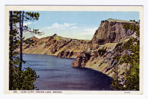 Title (front): Crater Lake National Park, Oregon (top, center) Llao CLiff (bottom center) Postmark: None, unmailed Stamp: "Place one cent stamp here" box Back caption: The encircling lava walls, jagged and exquisitely colored, tower 2000 feet above the lake, itself 2000 feet deep, and is one of the deepest and by far the bluest water lake in the world. The face of Llao Rock is the highest vertical surface on the Rim, being 1997 feet above the surface and 8046 feet above sea level. Crater Lake is six miles long and four half miles wide. Vertical Divider Text (back): "C.T. ART-COLORTONE" REG. U.S.PAT.OFF.--WESLEY ANDREWS CO., PORTLAND, ORE. Card Number(s): 871 (front upper left corner), 7A-H982 (bottom right corner)
